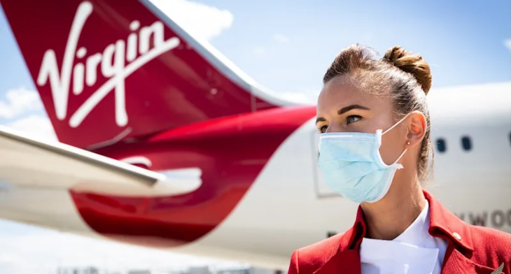 A masked Virgin Atlantic crew member