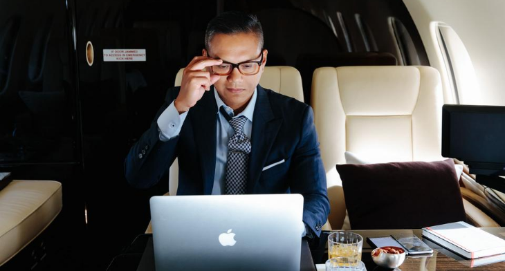 Passenger using laptop on business jet